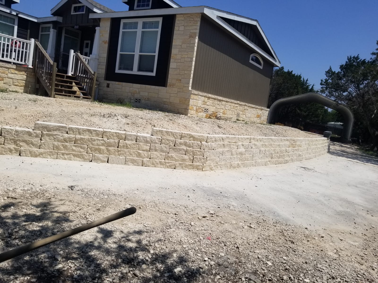 Large light stone retaining wall on a sloped front yard