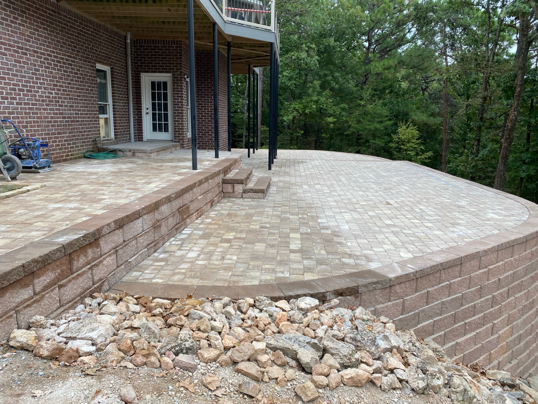 Retaining wall and paver deck project behind a brick home